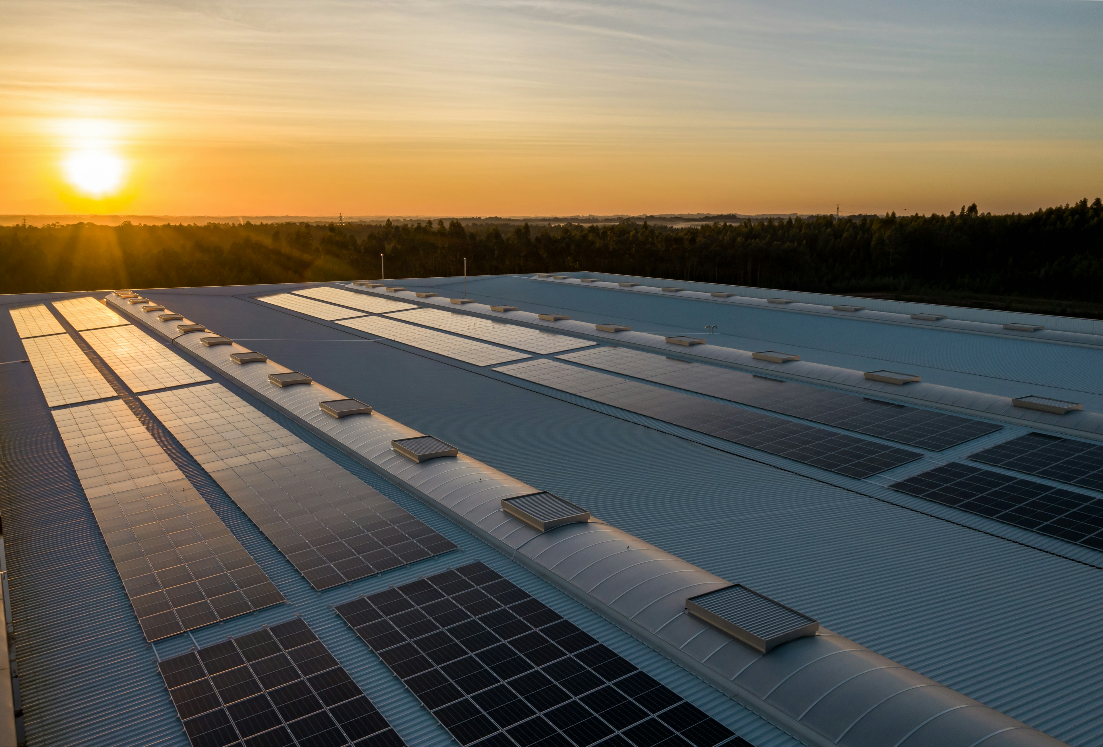 Solar array across a factory roof at sunset, a solar manufacturing facility